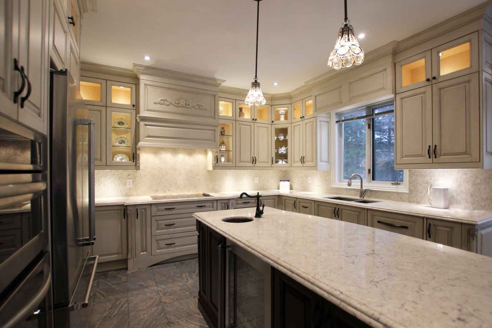 Luxurious kitchen with cream cabinets, granite countertops, and island.