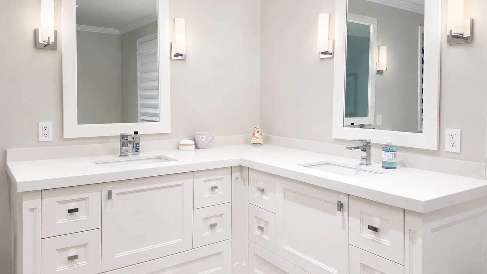 A modern white bathroom vanity with two sinks and mirrors.