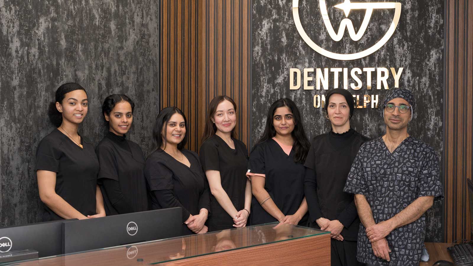 The friendly and professional team at Dentistry on Guelph, including Dr. Reza Shahhaidari and Dr. Mozhgan Karbalaei smiling in their modern clinic.