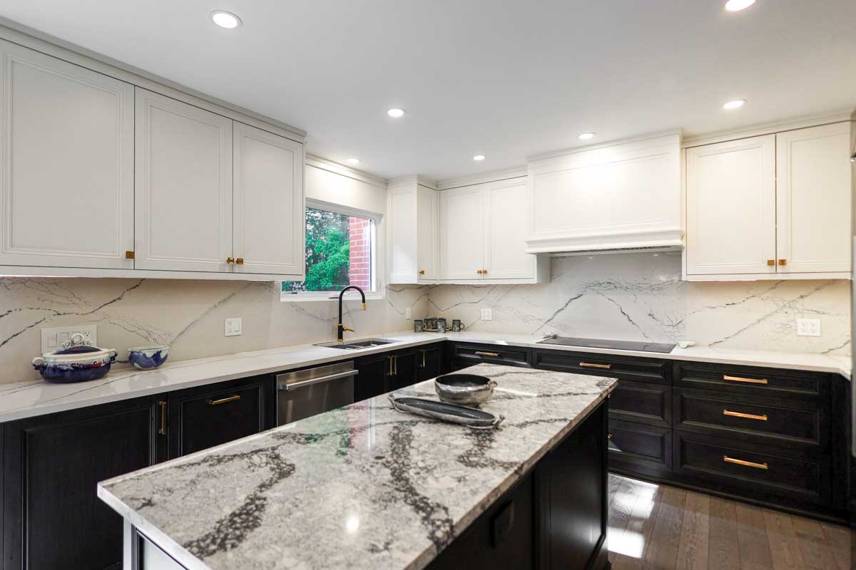 Modern kitchen with black and white cabinets and a marble island.