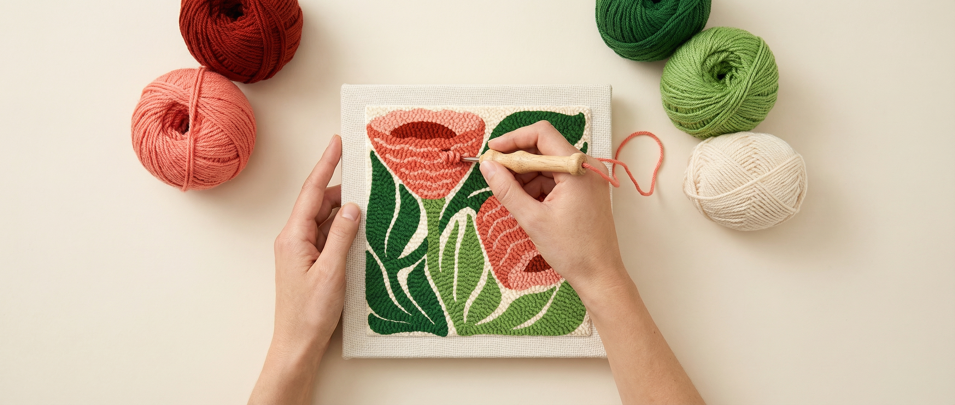 Hands punch needle art with yarn and floral design.
