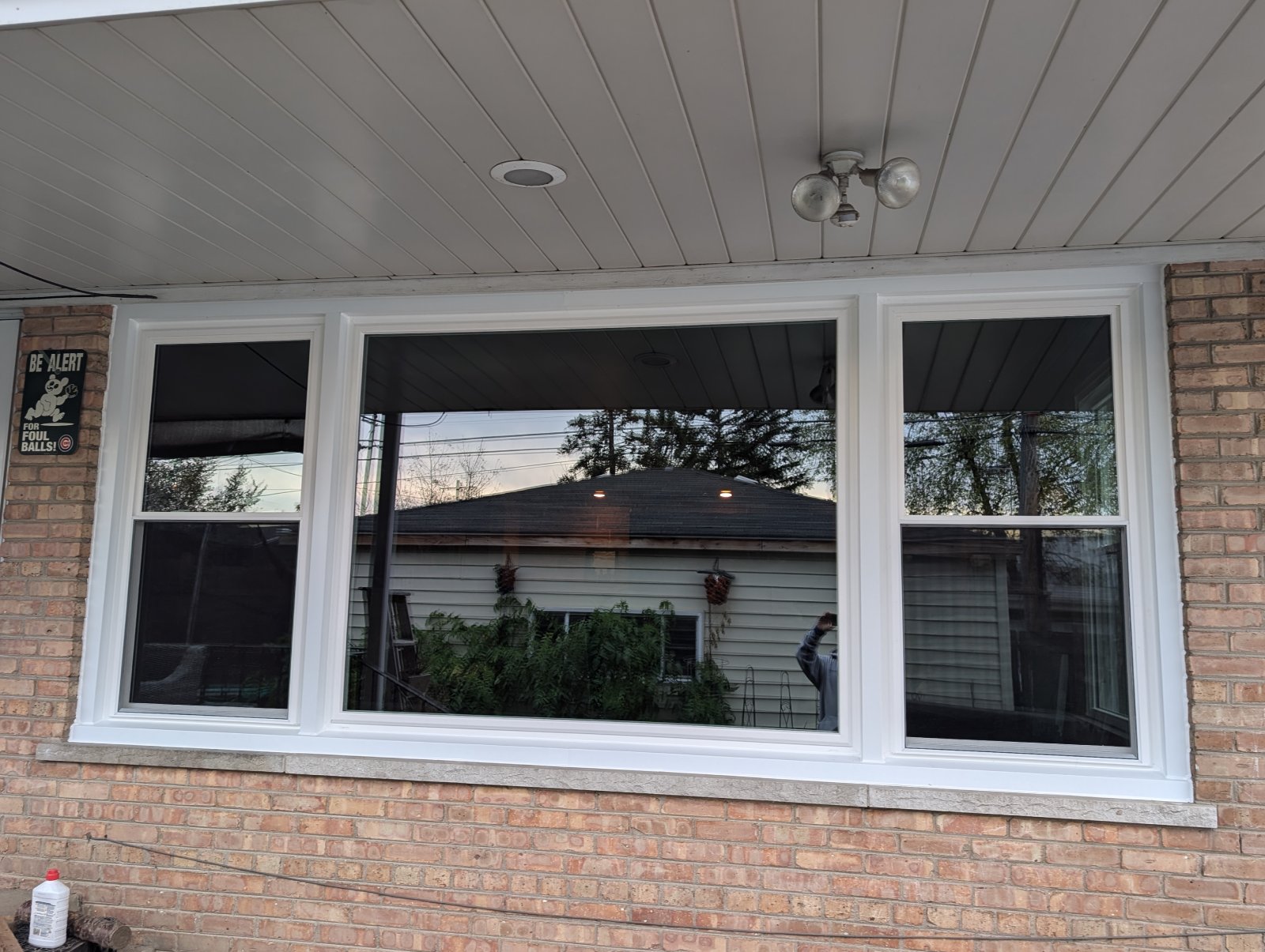 New white windows installed on a brick house exterior