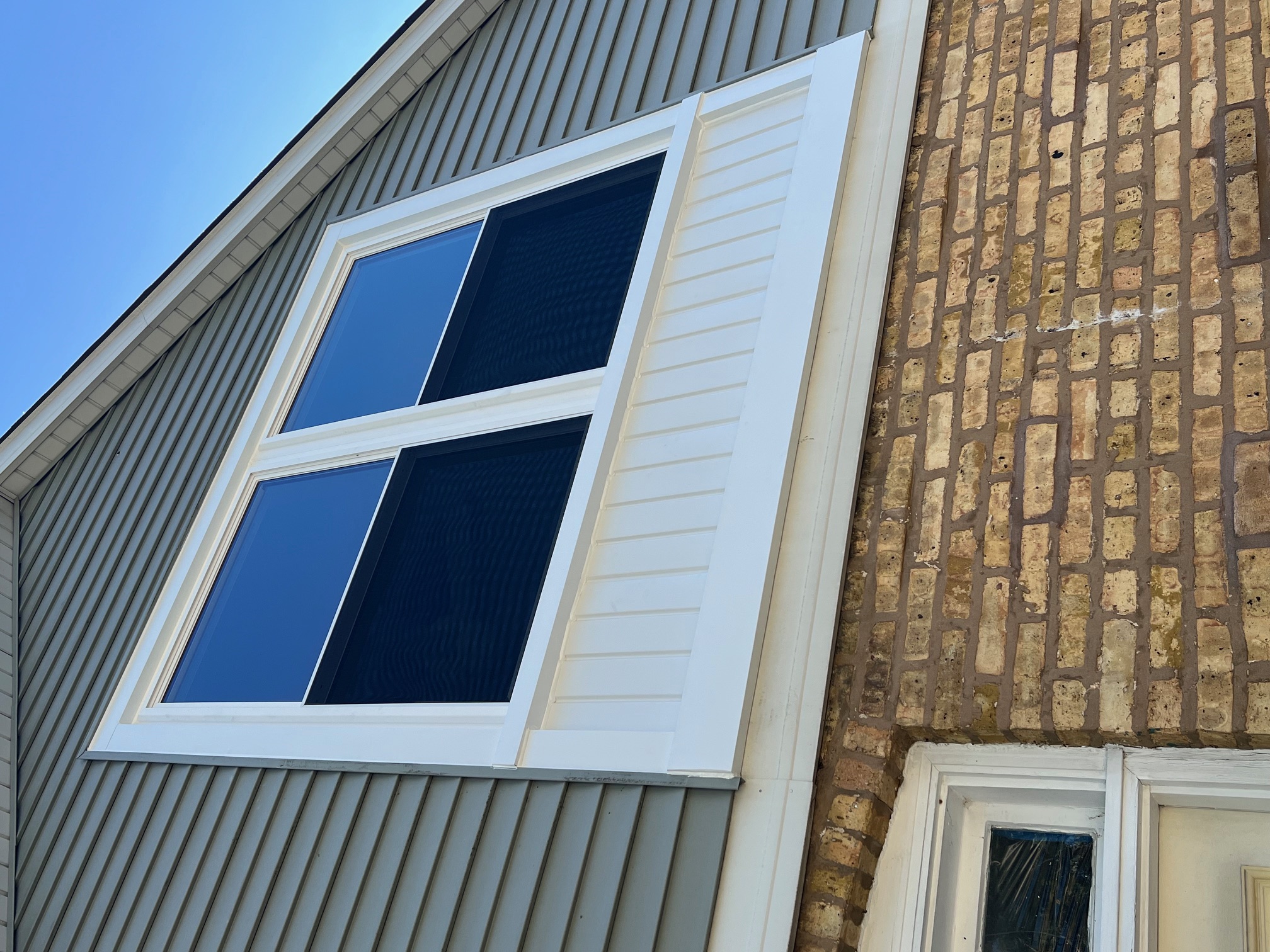 A modern window with white trim on a house
