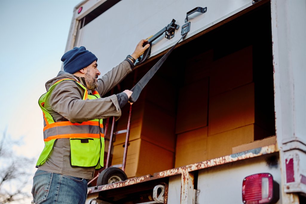 A person secures boxes in the back of a truck
