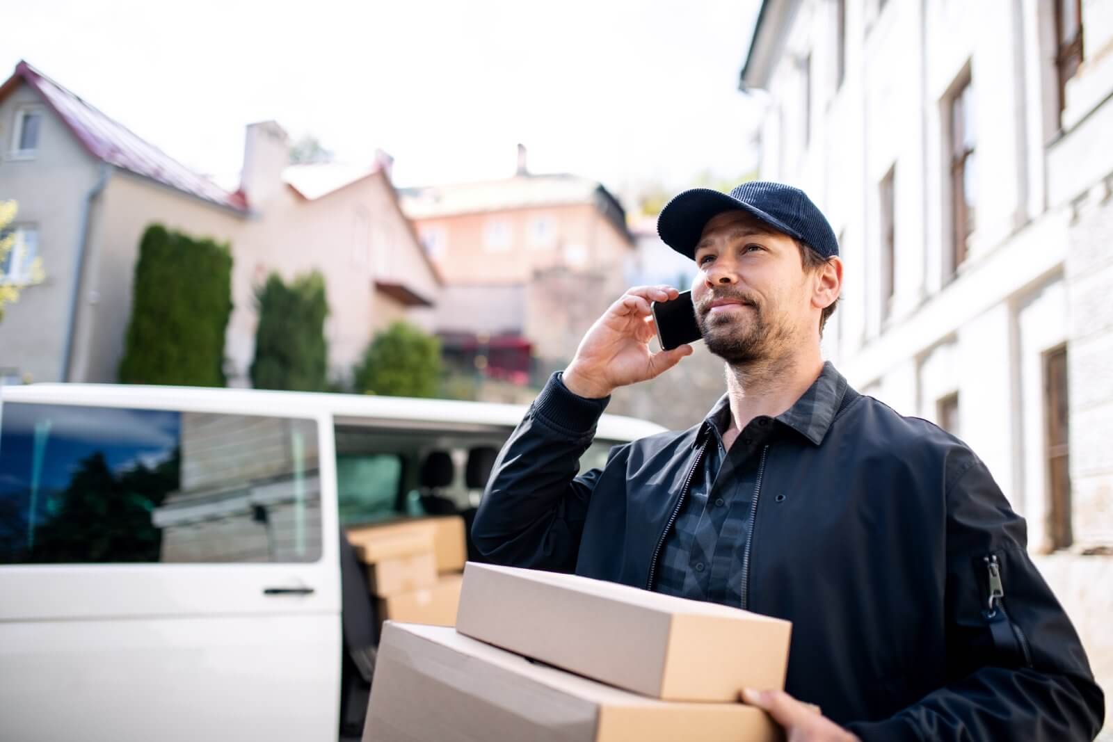 Delivery person on phone with packages