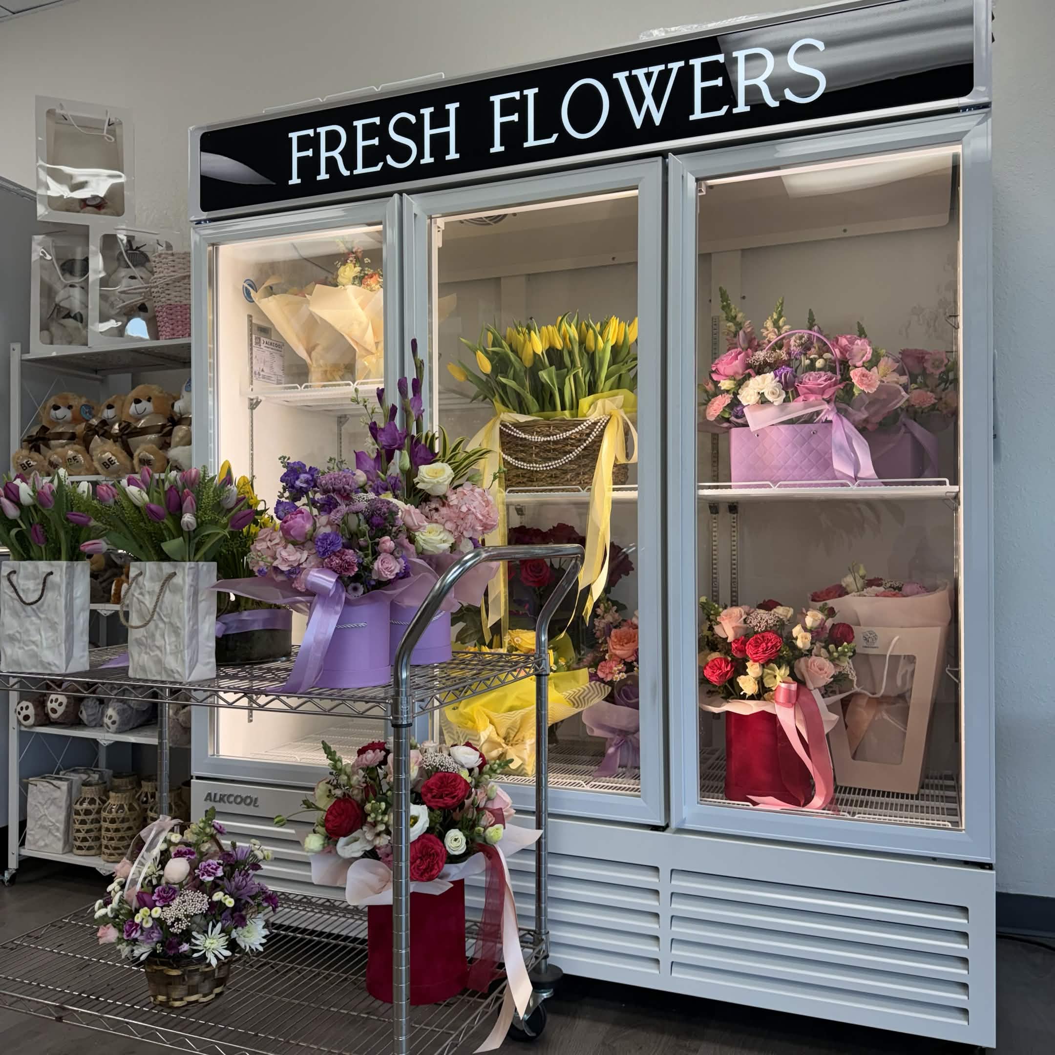 A refrigerated display case filled with fresh garden-inspired arrangements for sympathy and celebration