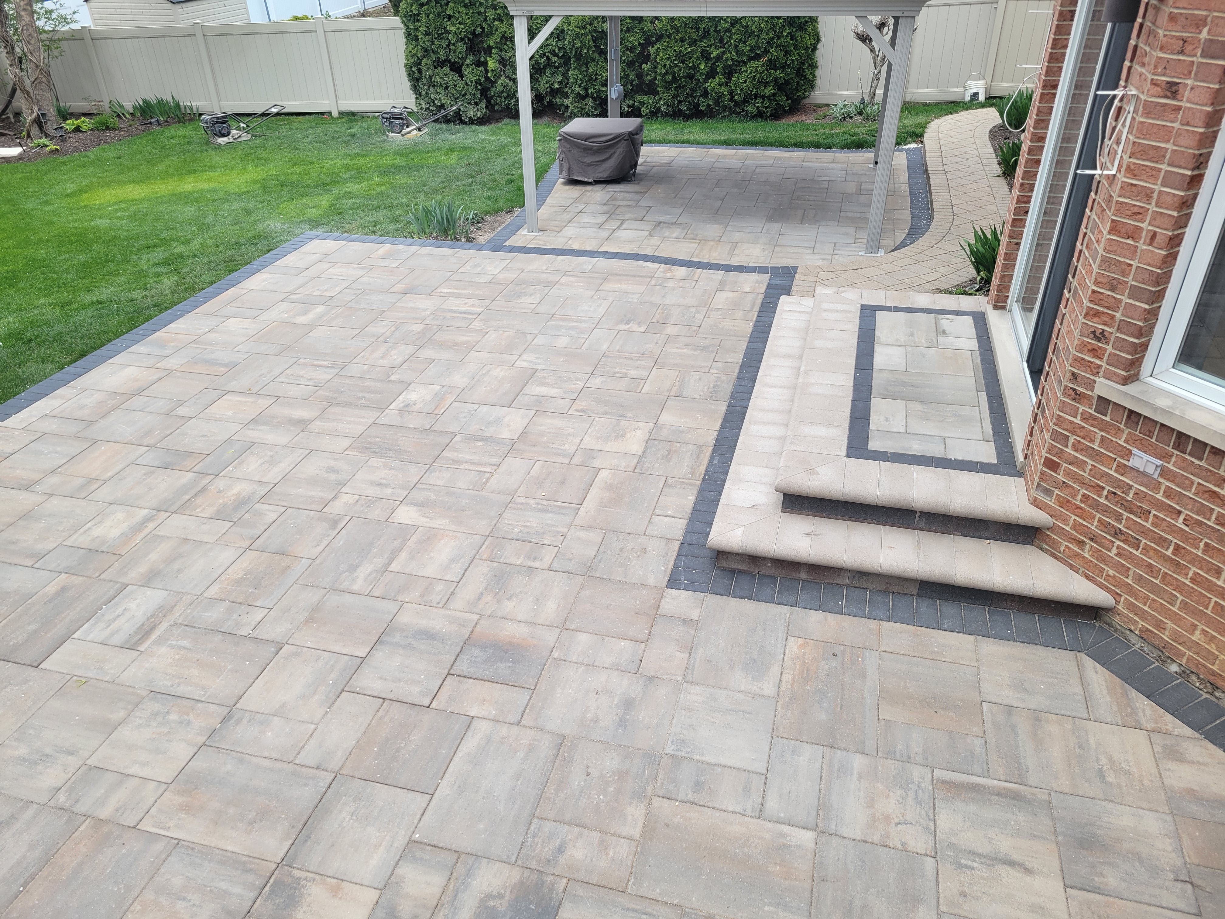 Newly paved patio with lush green lawn