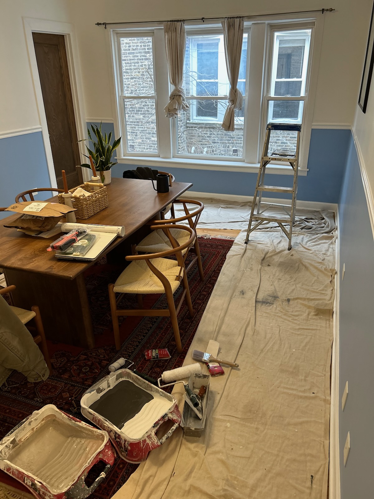 A person prepares a wall for painting in an interior room