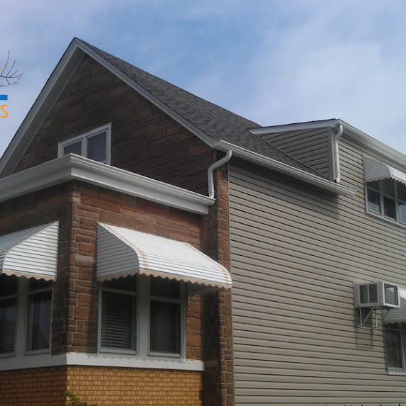 An awning over a brick and siding house
