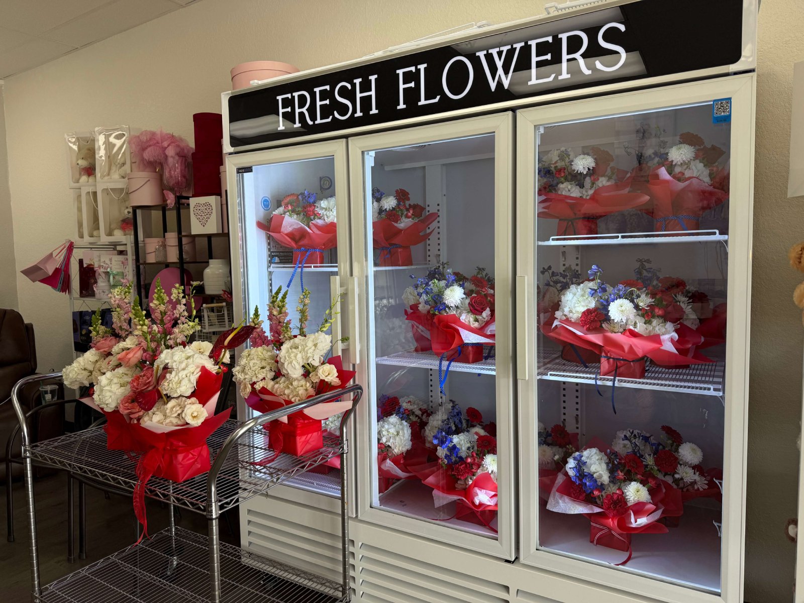 A flower shop cooler filled with fresh flower arrangements.