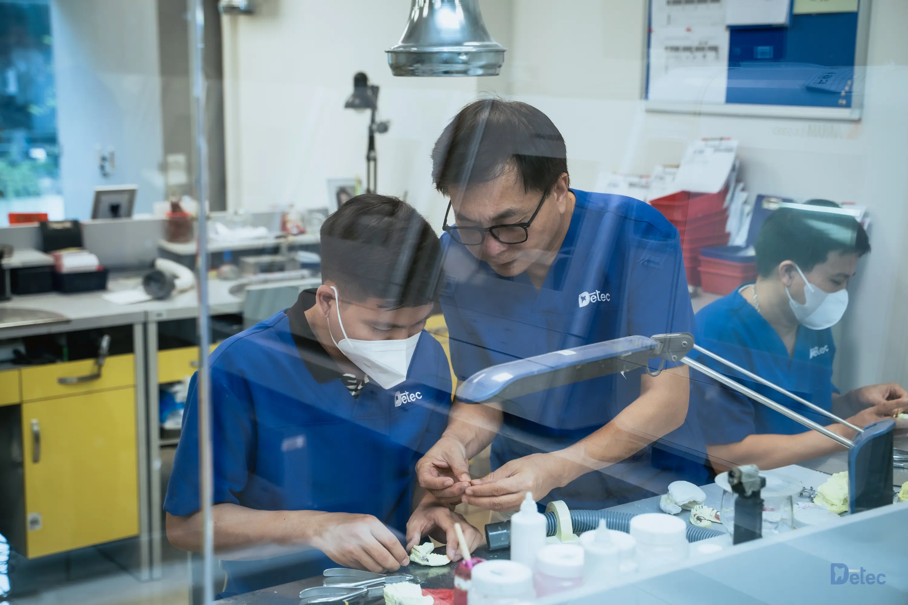 Professional dental technicians working with precision equipment