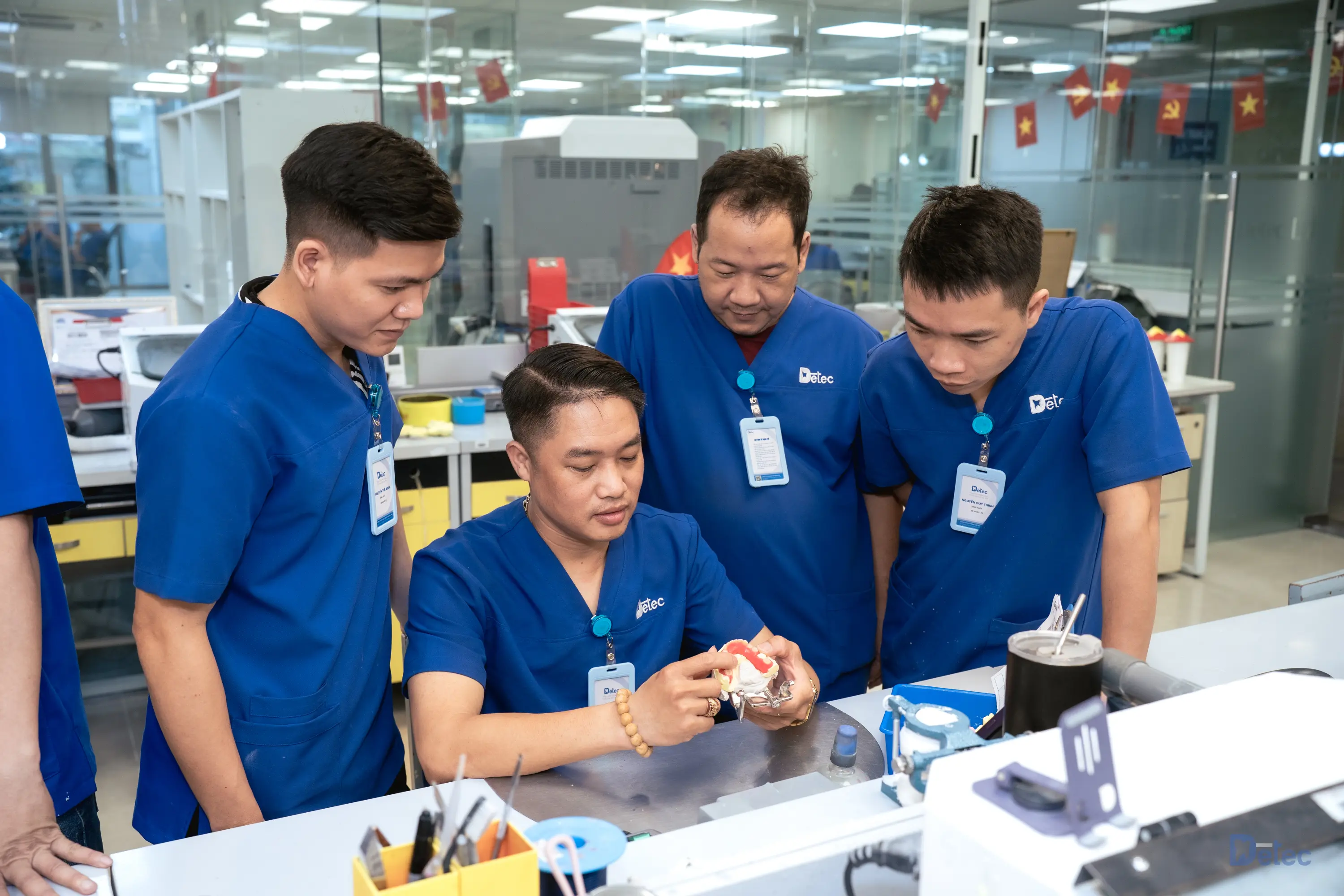 Customers and technicians examining dental models