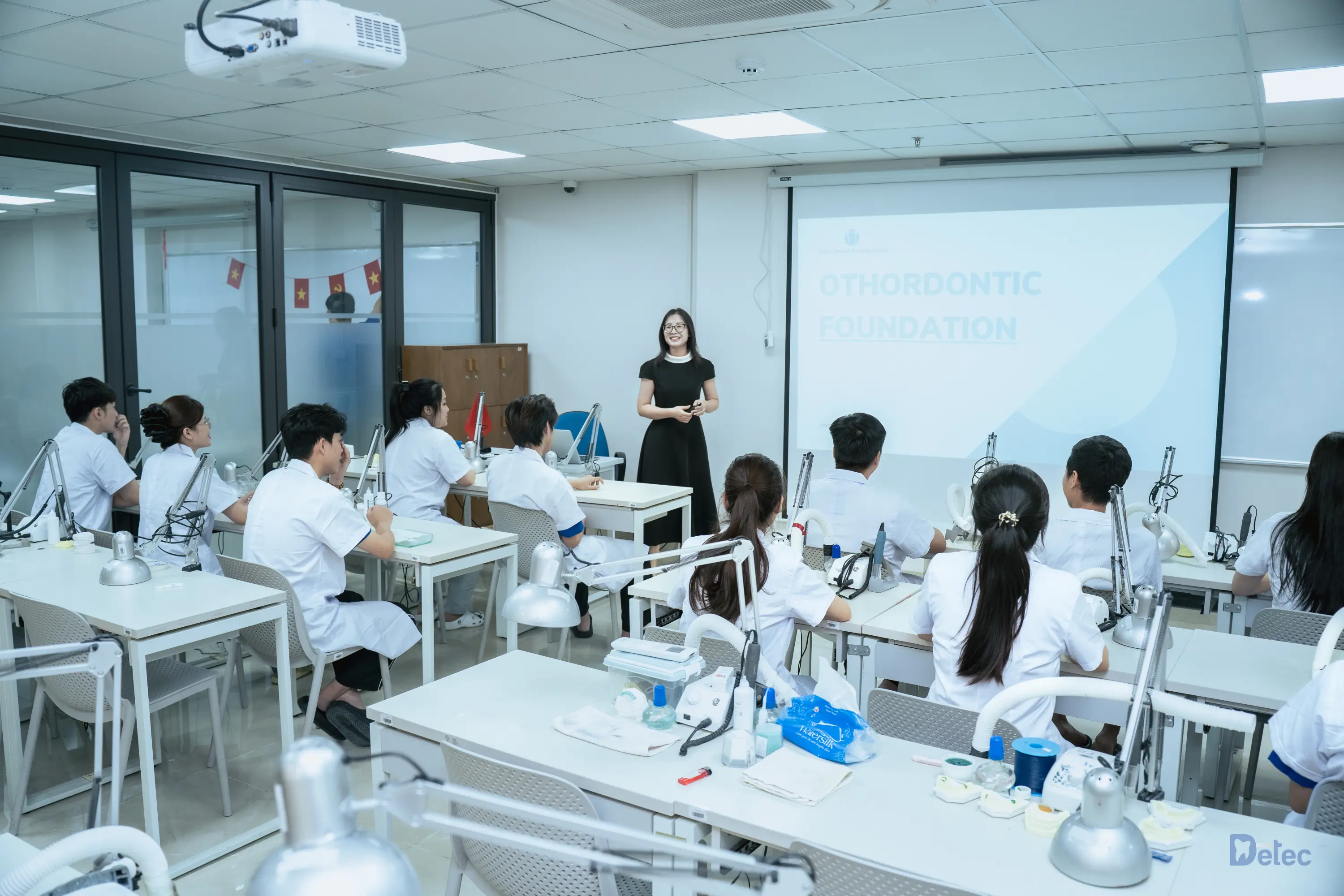 Students in a dental lab class with a presentation on orthodontic foundation.