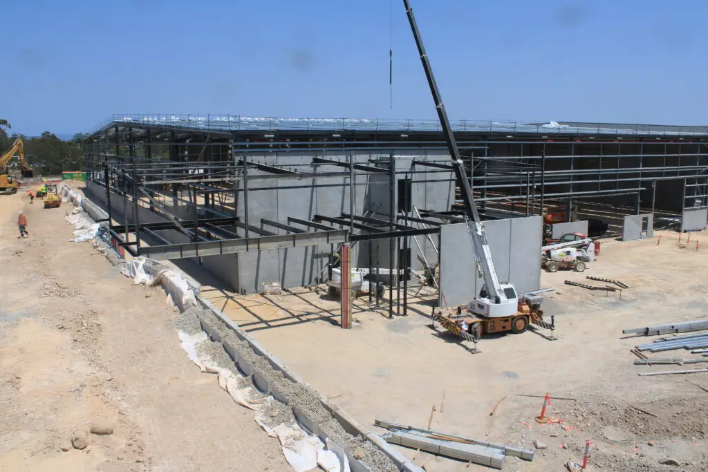 Large building under construction with cranes and heavy machinery.