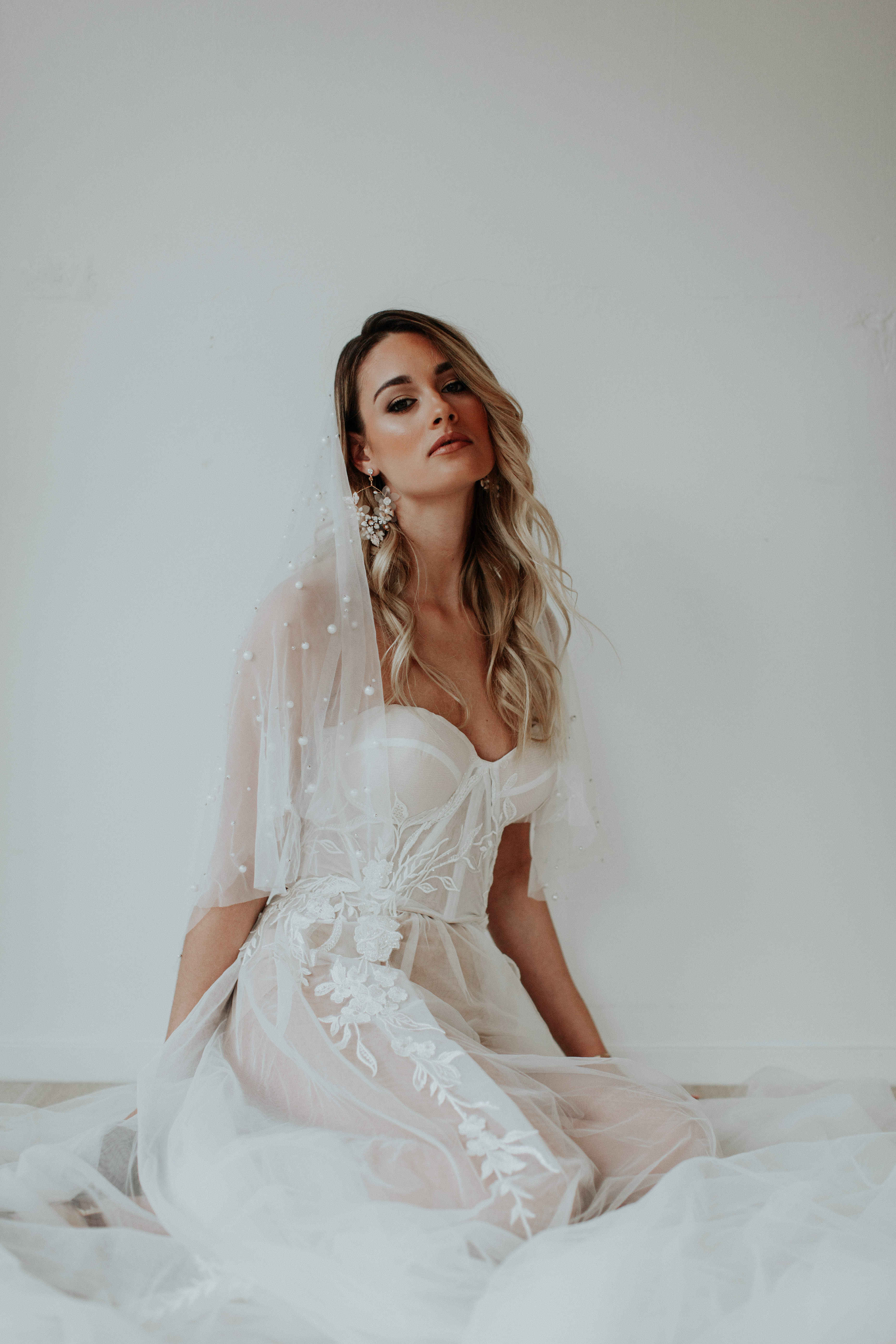 Bride holding her dress showing her gorgeous bridal jewelry