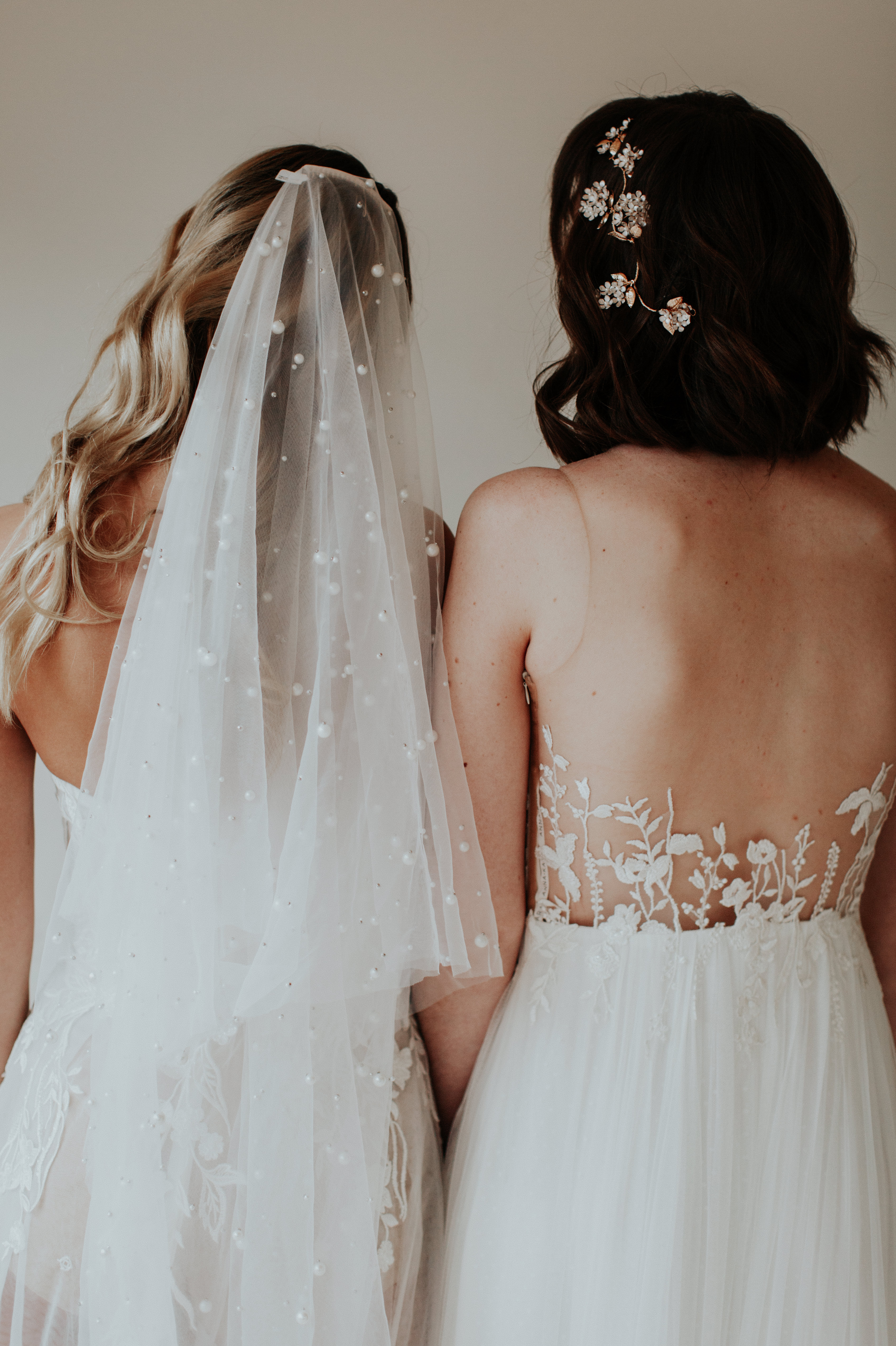 A person in a white wedding dress with a floral veil.