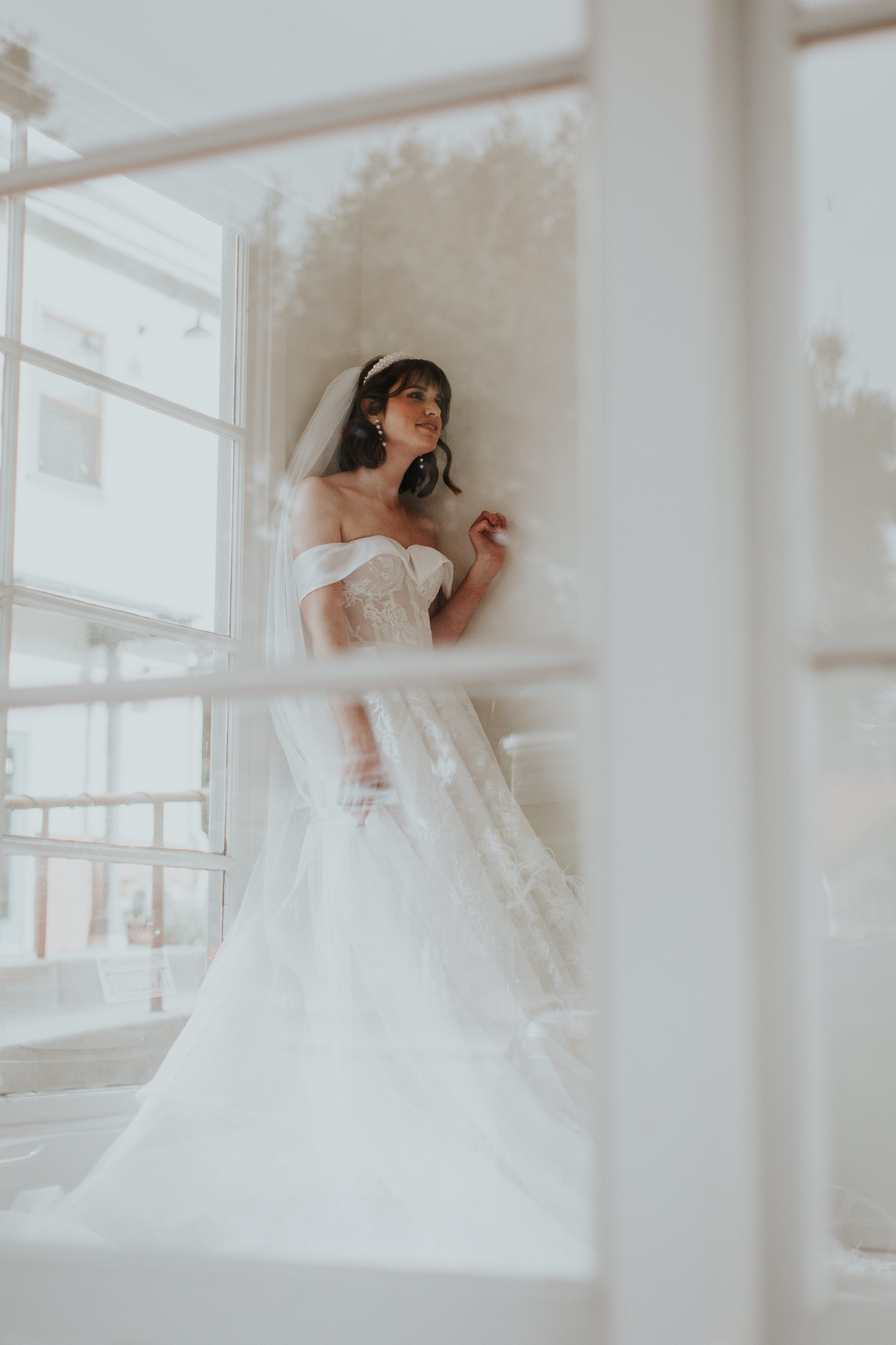 Bride adjusting a veil in a wedding dress