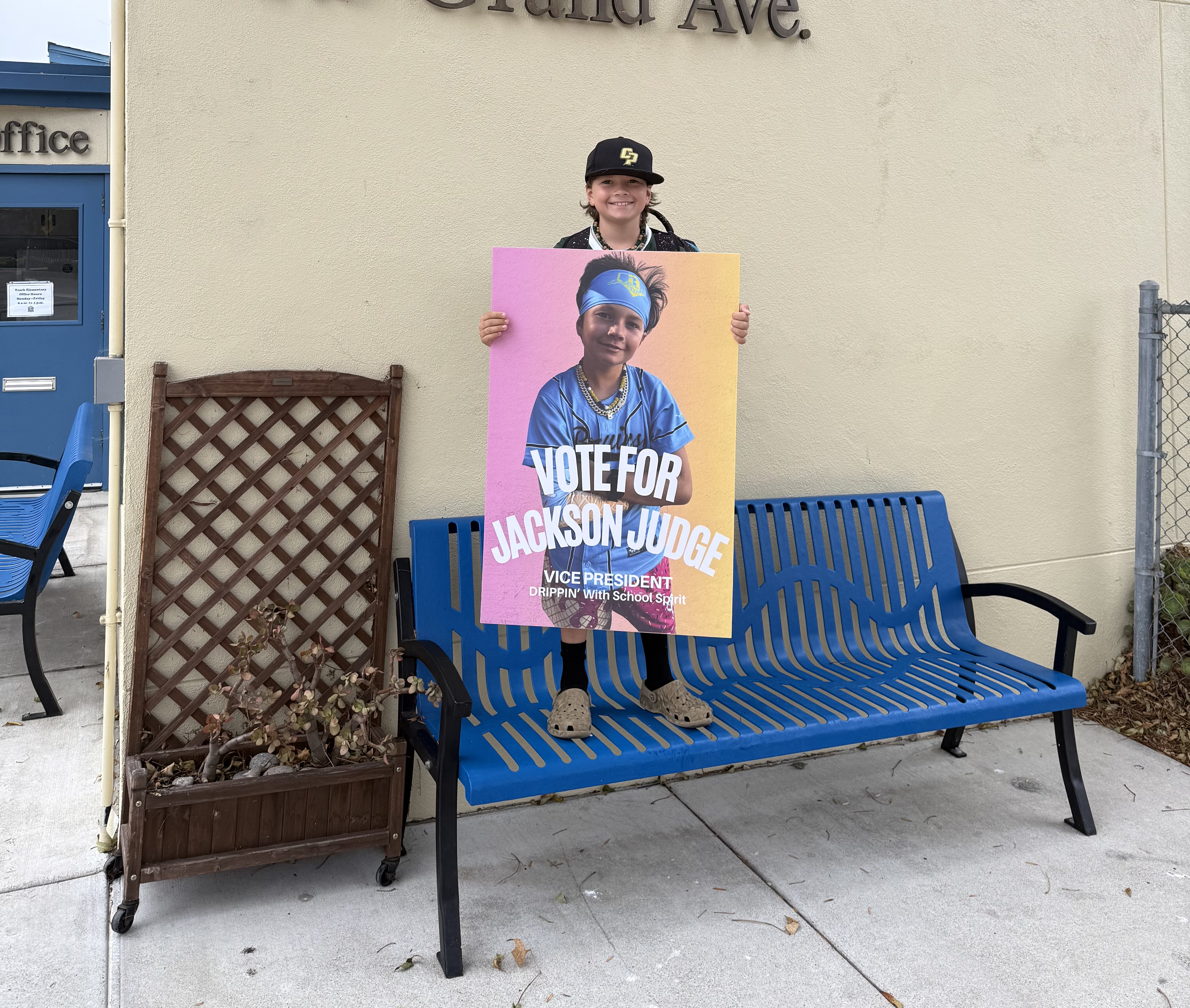 Student holds a colorful school campaign poster