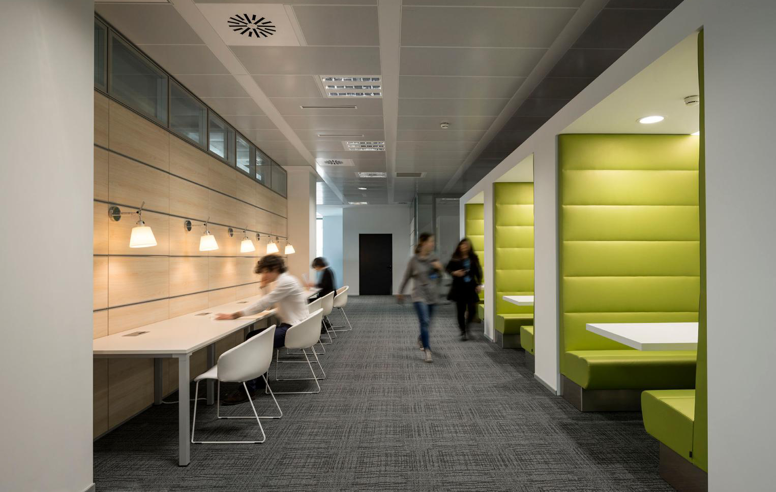 Moderner Co-Working Space mit Arbeitsplätzen und Pflanzen.