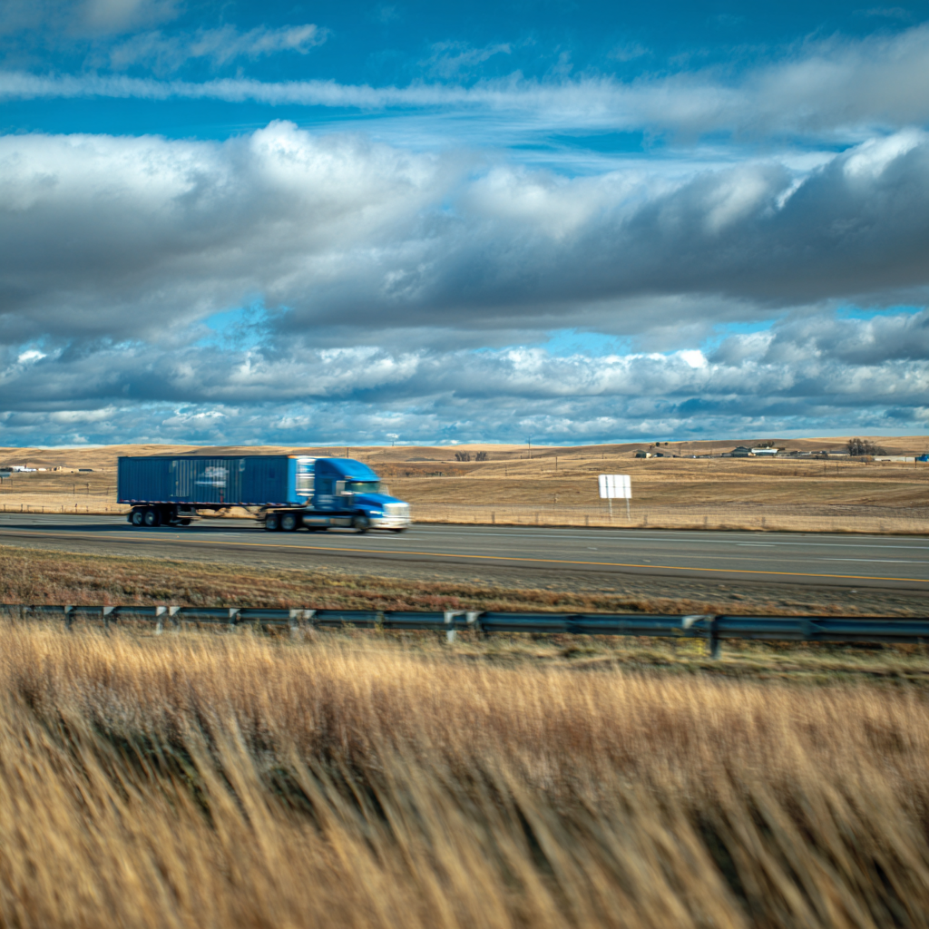 Blue semi-truck driving on highway