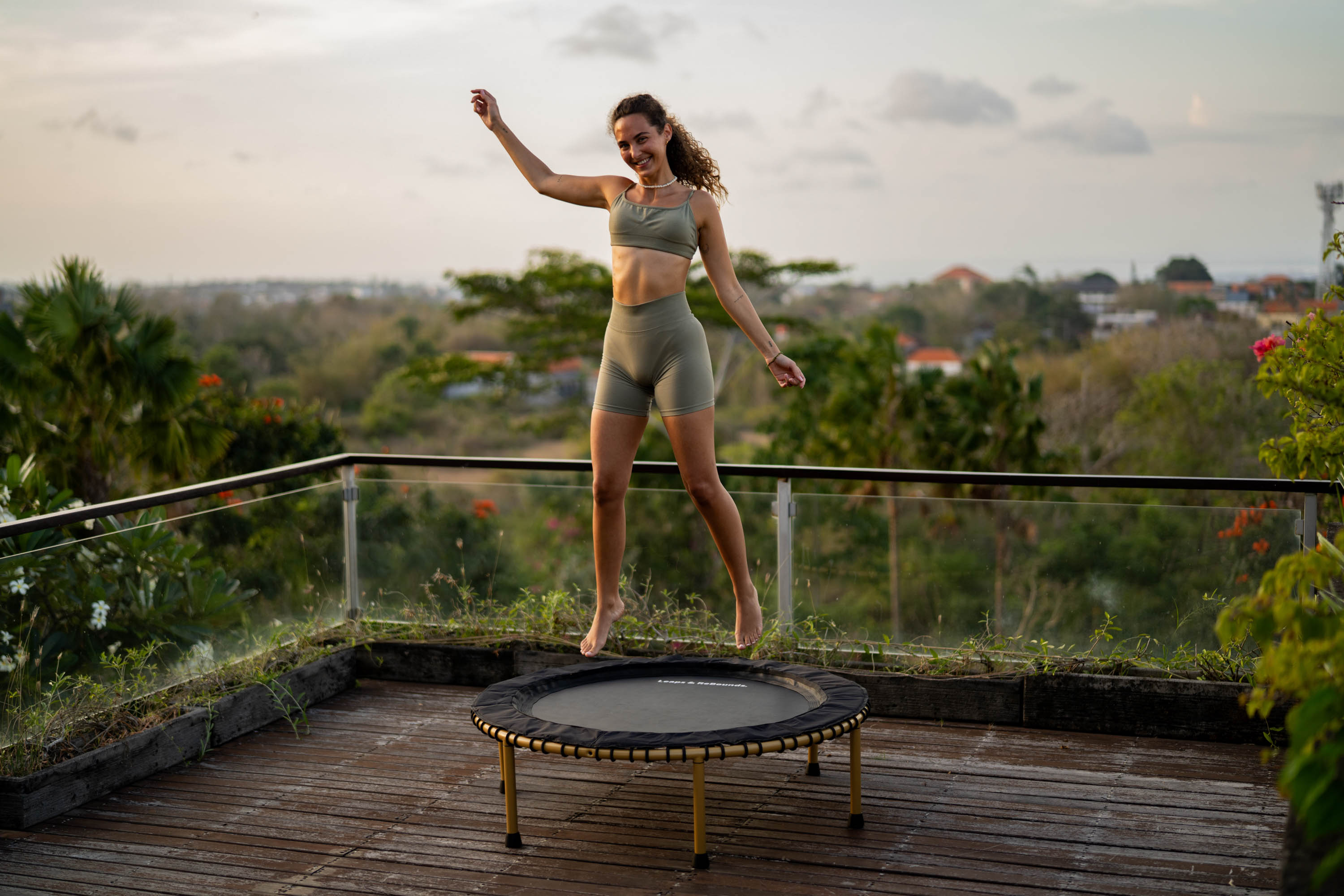 Person bouncing on trampoline outdoors