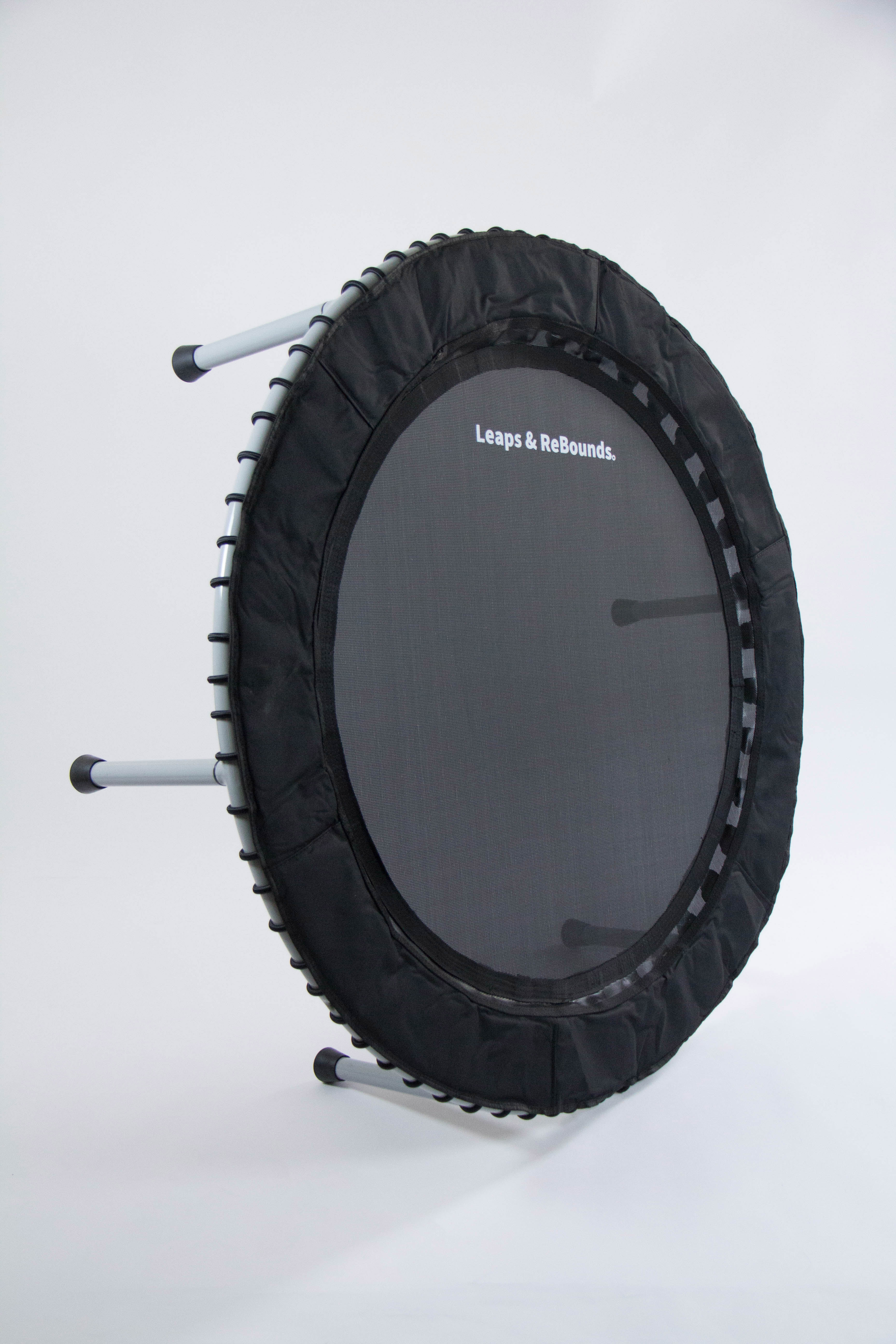 A small black exercise trampoline with three metal legs visible