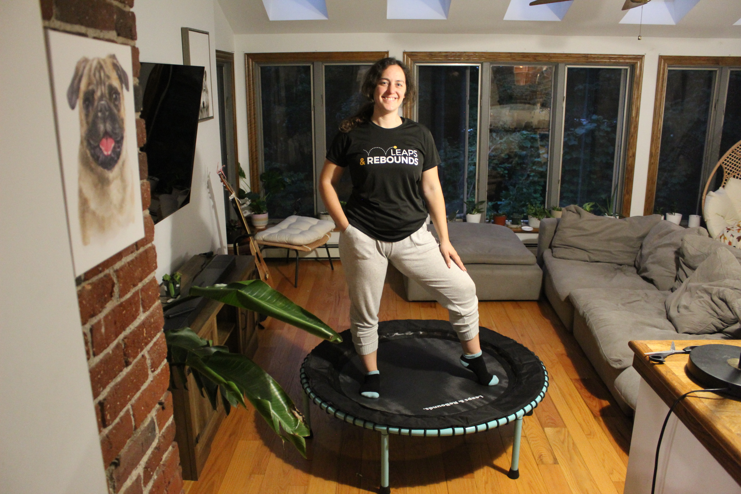 Person bouncing on a small trampoline in a living room