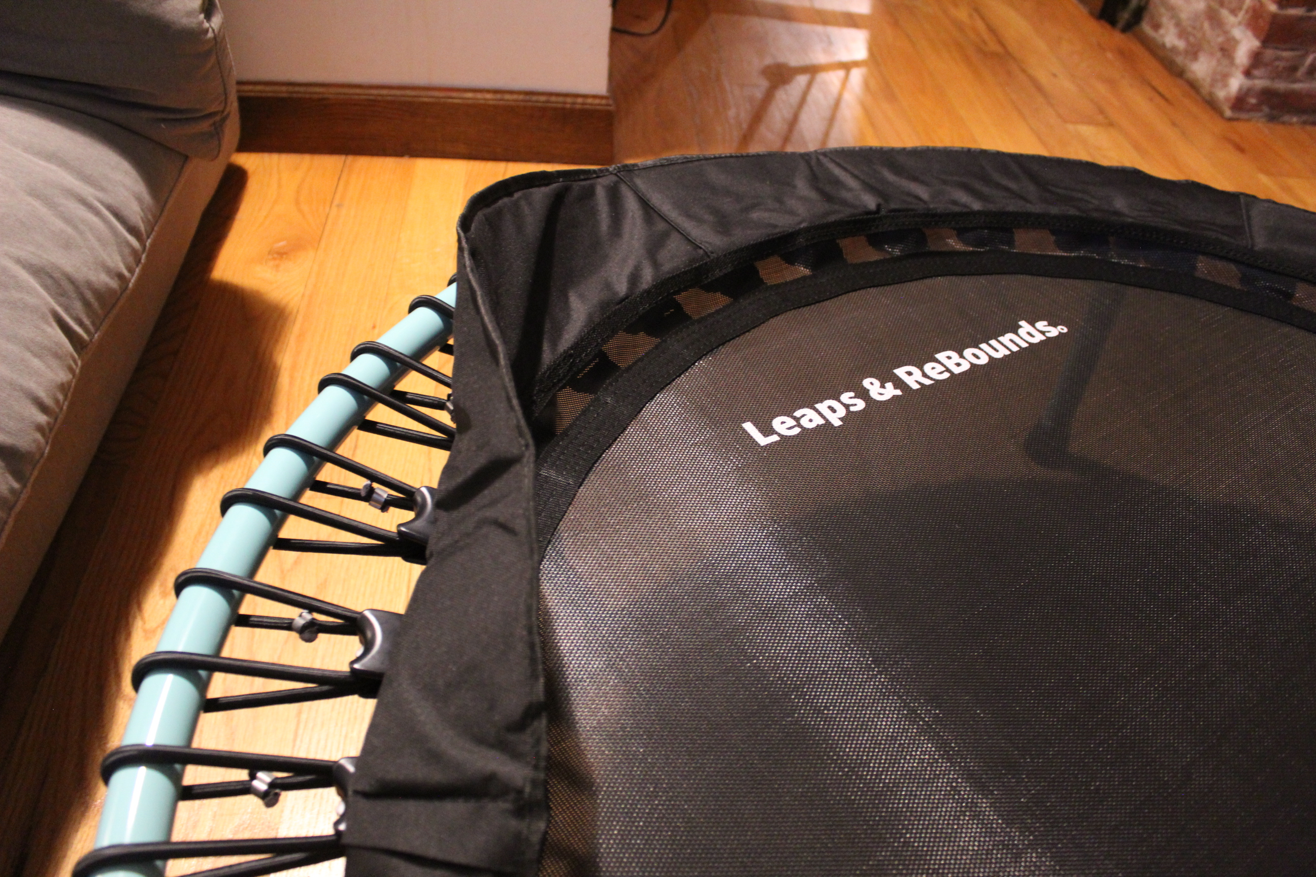 Small trampoline with green frame and socks on top.