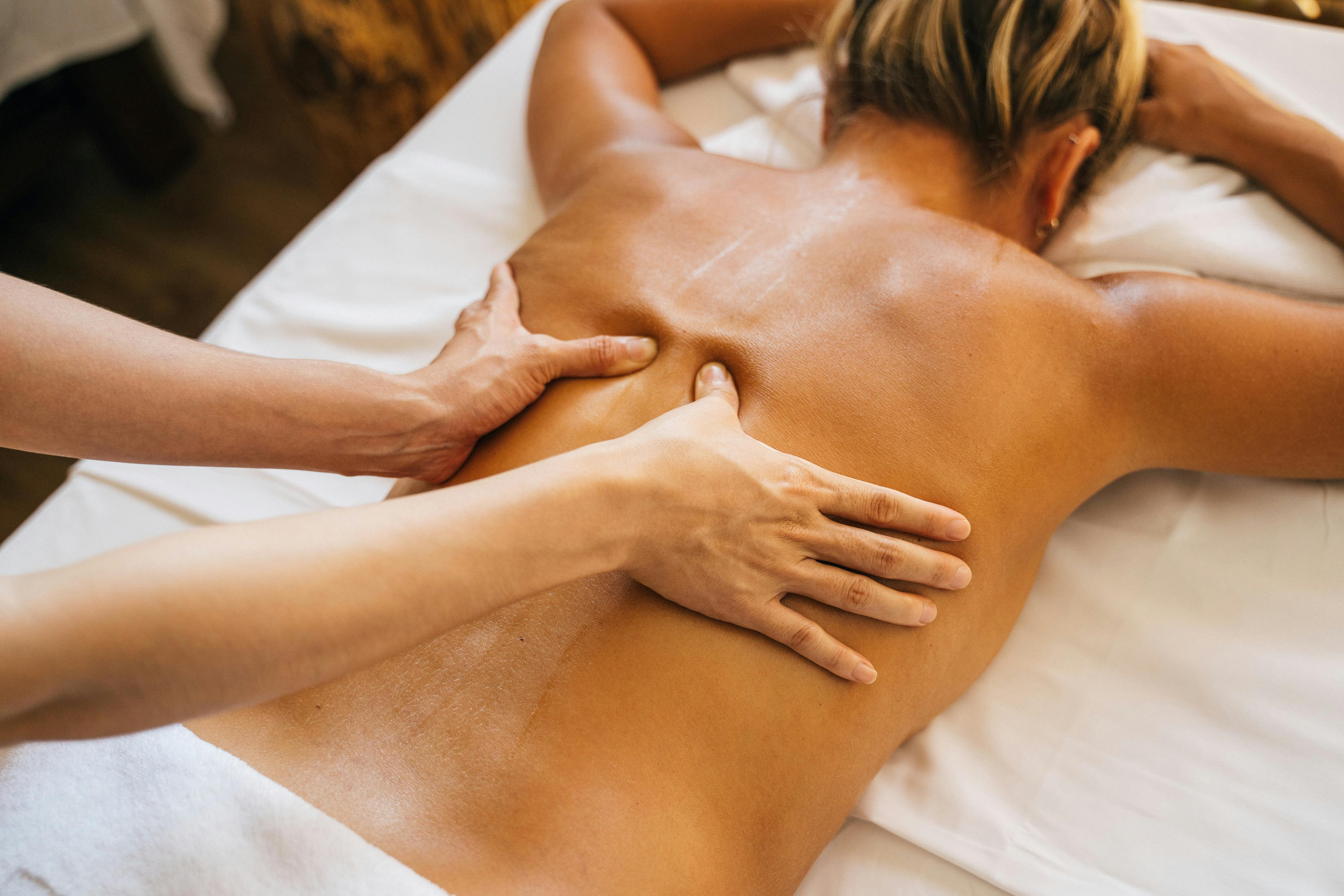 Person receiving a relaxing back massage on a white table.