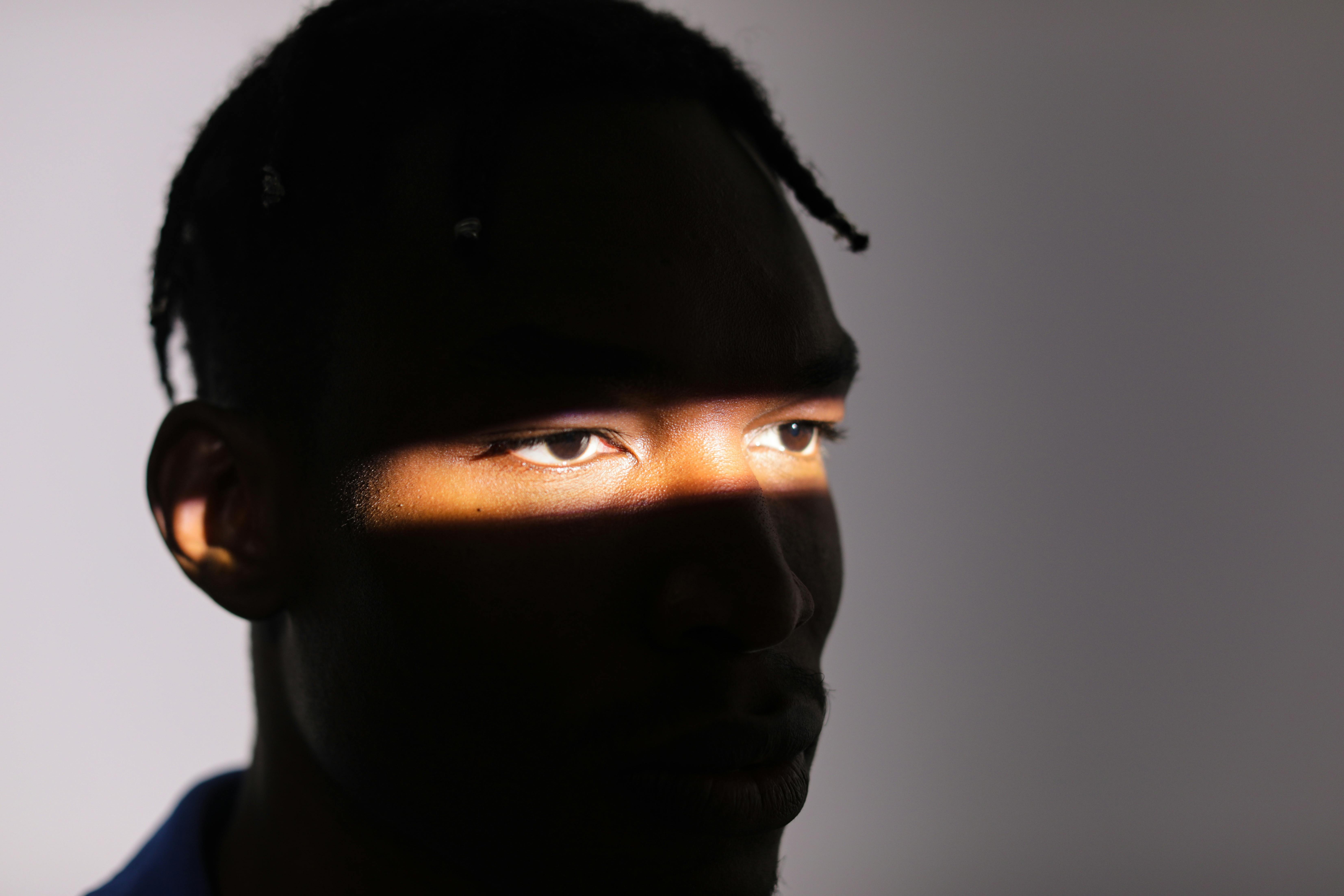 A face partially illuminated by a narrow beam of light.