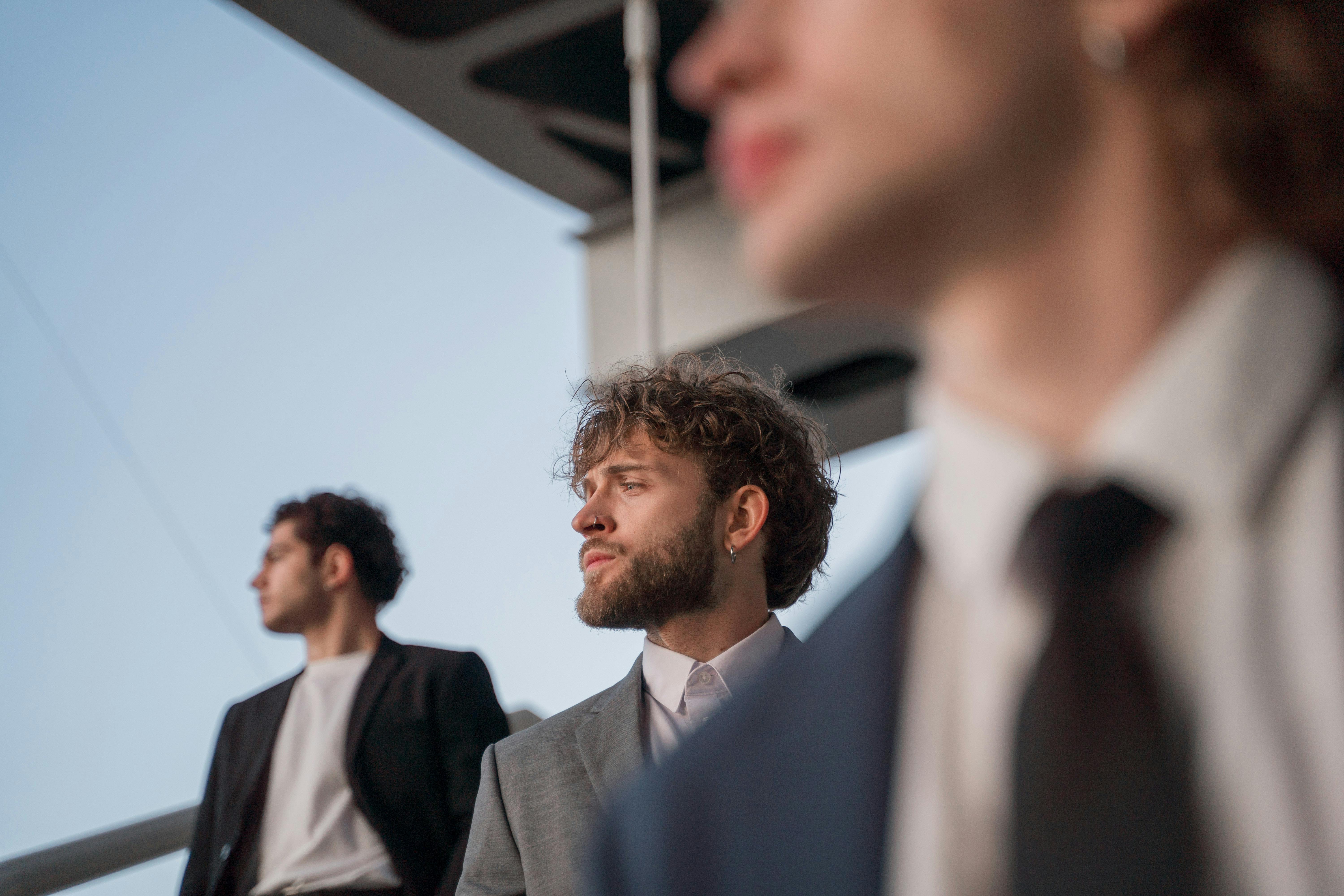 Three men in suits looking away from the camera.