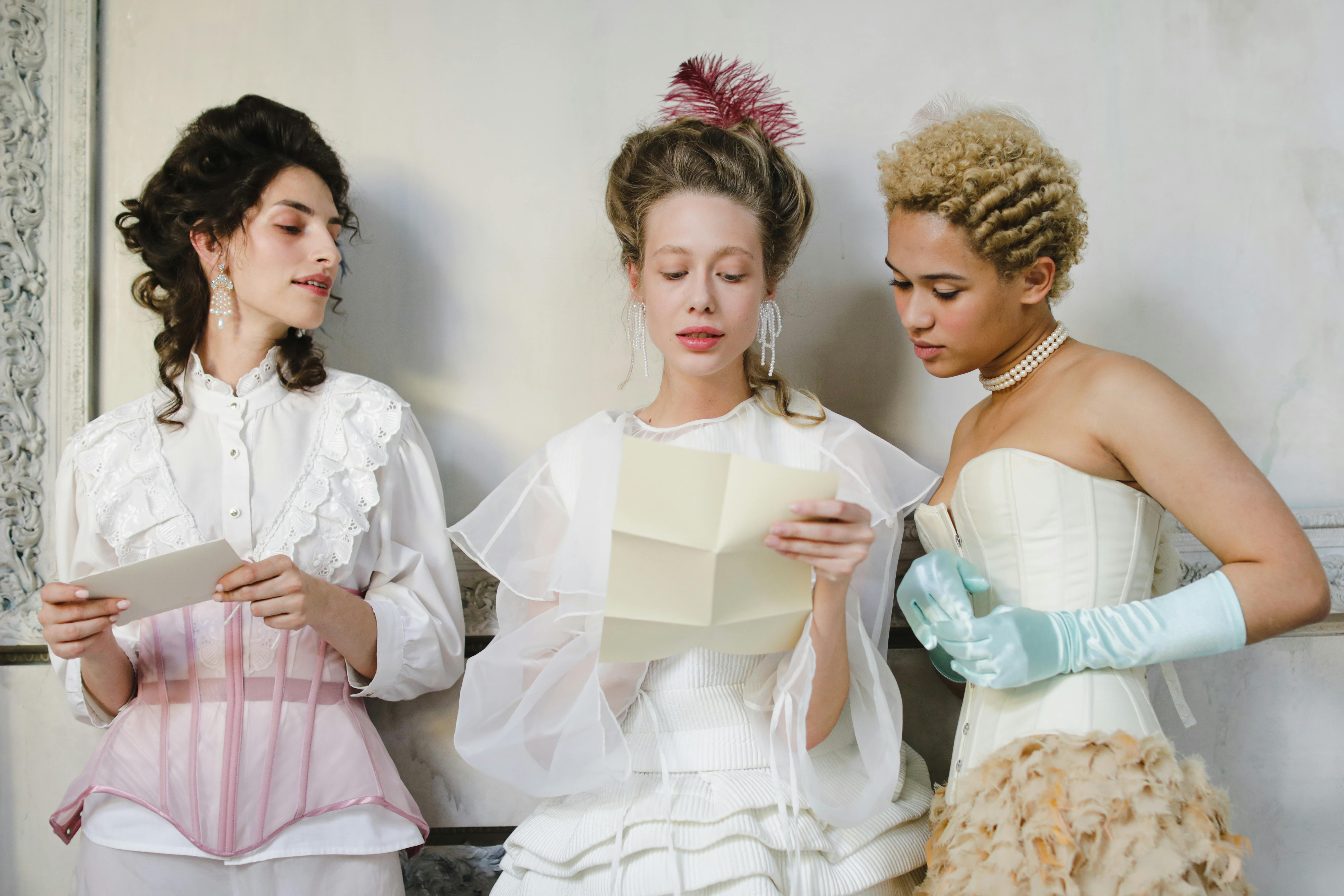 Three people in vintage attire reading letters together.