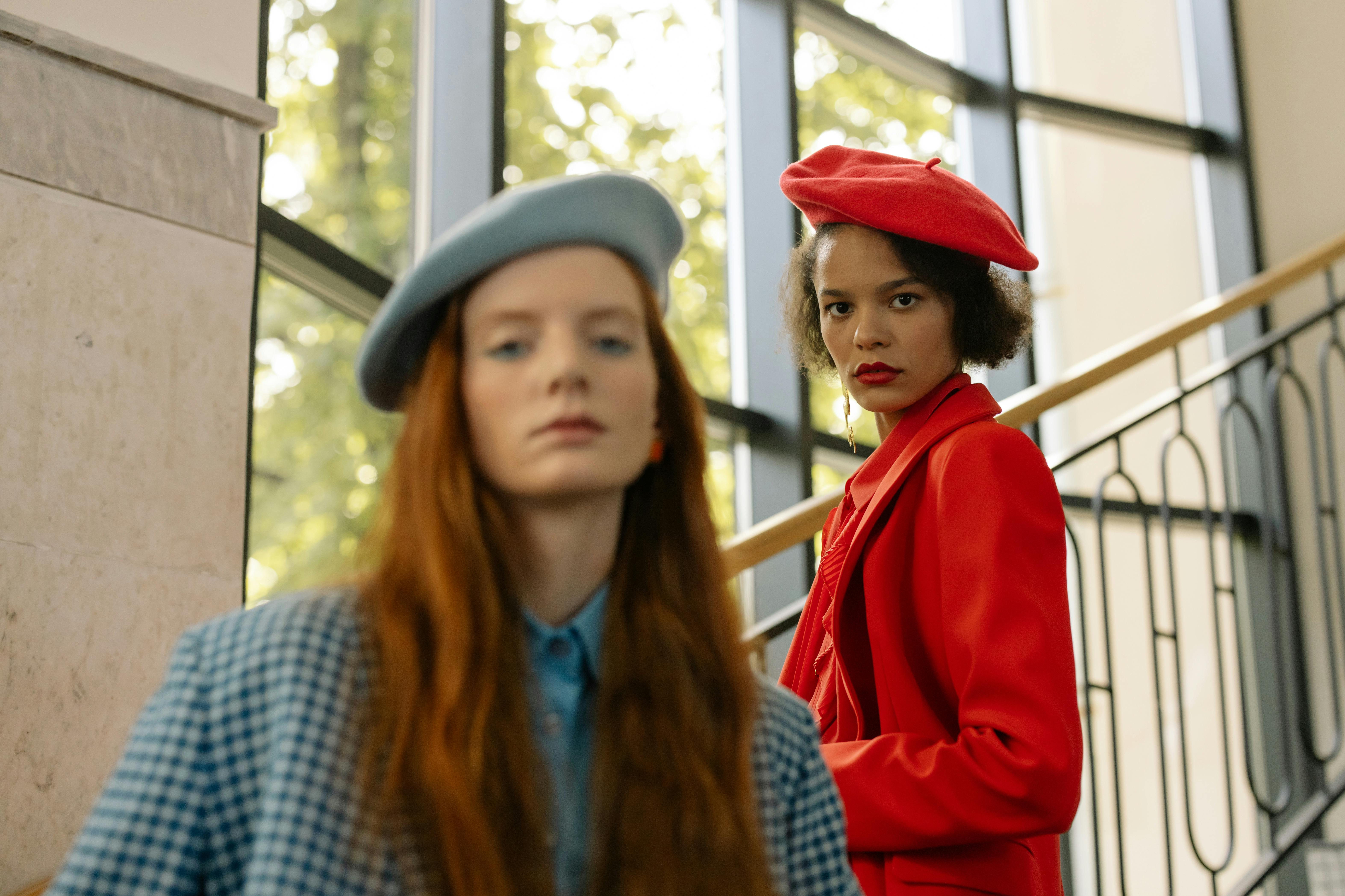 Two people wearing berets stand on a staircase.