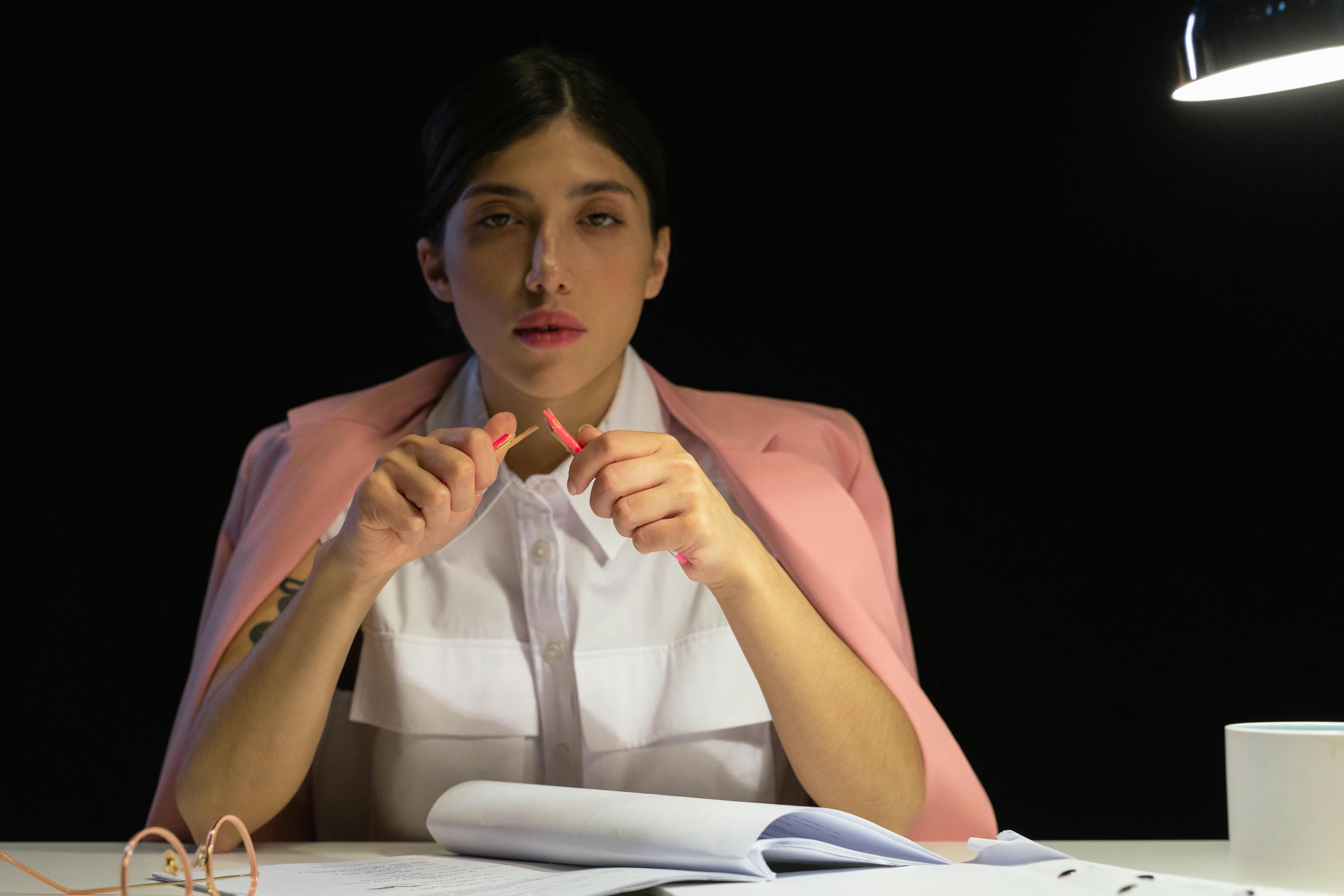 Person breaking a pencil in frustration at a desk.