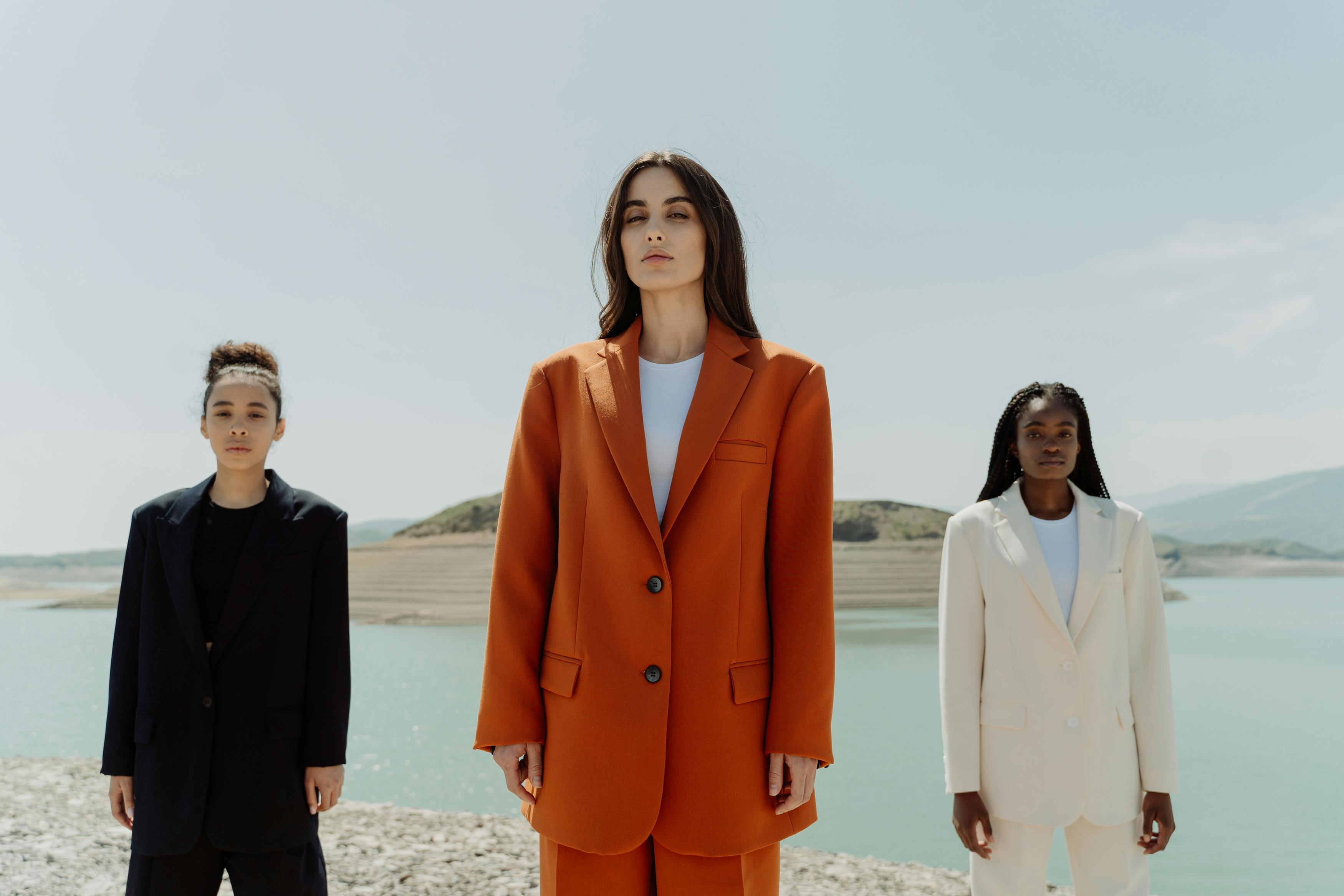 Three people in suits stand by a body of water.