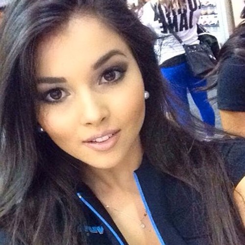 Close-up selfie of a young woman with dark hair and makeup.