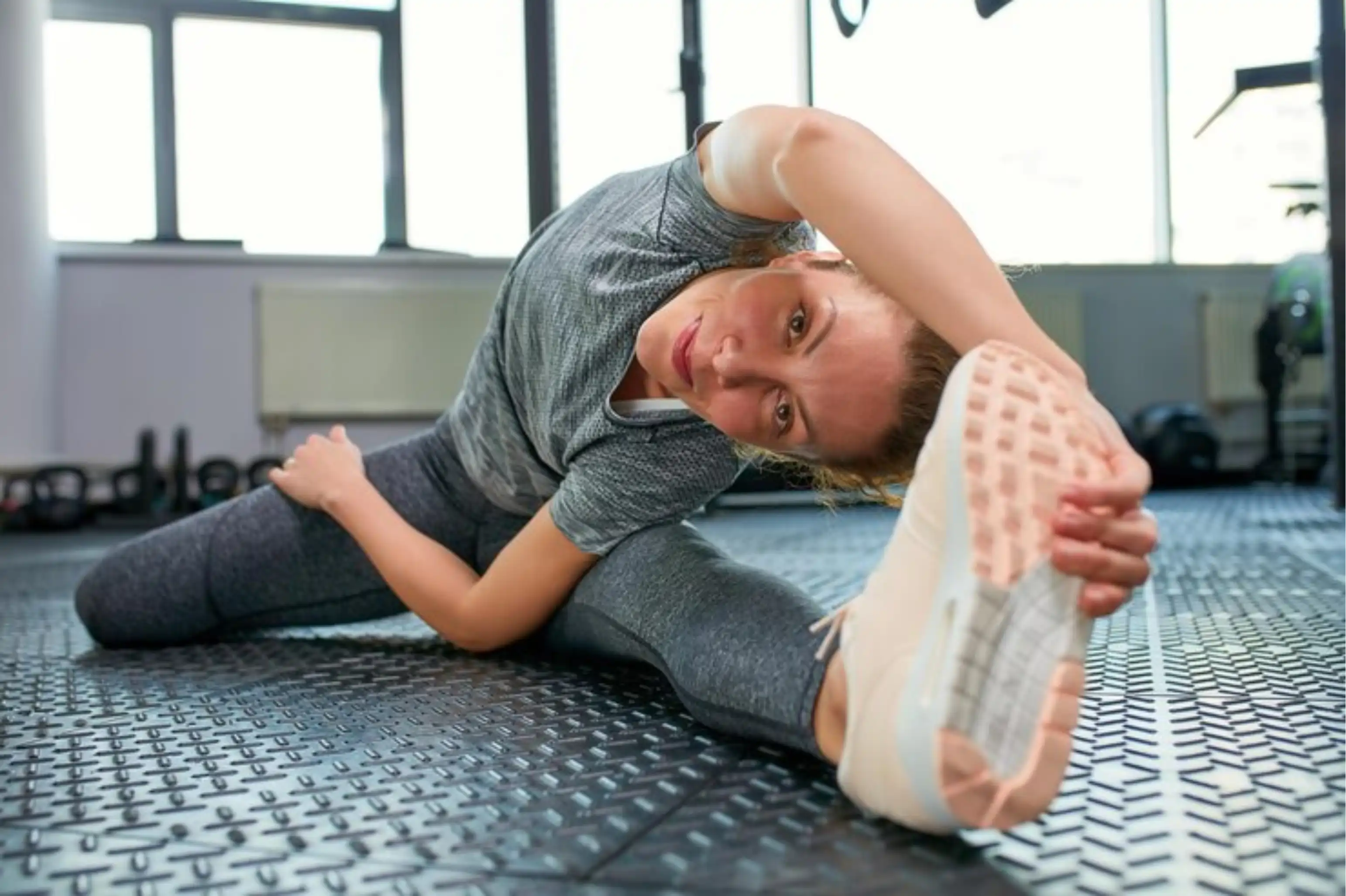 Athlete stretching in a gym on a mat.