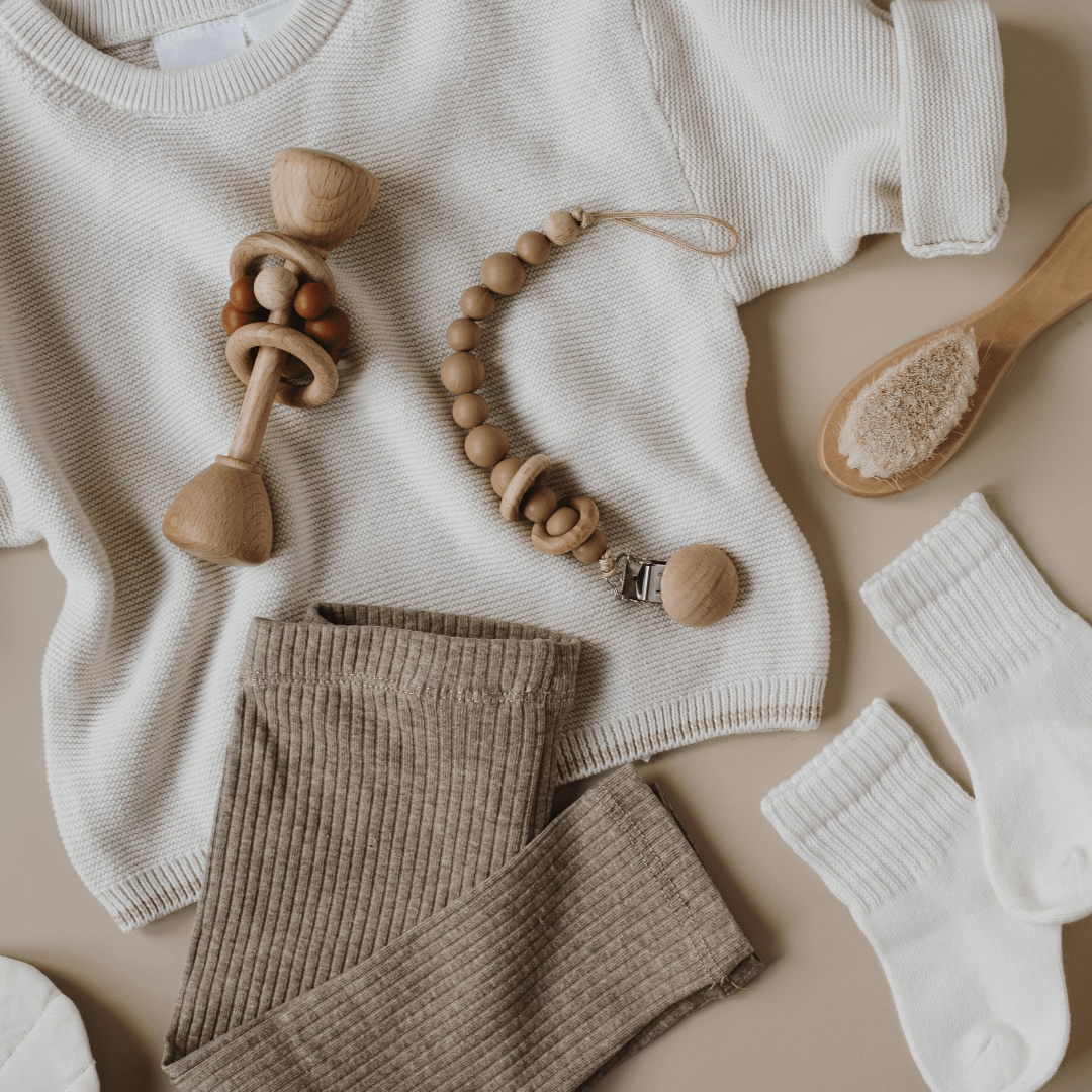 Baby clothes and accessories arranged in a flat lay.