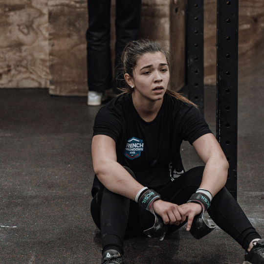 Woman looking exhausted after overtraining in the gym.