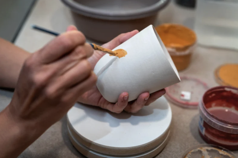 Ateliers créatifs à Bruxelles, mains peignant et modelant.