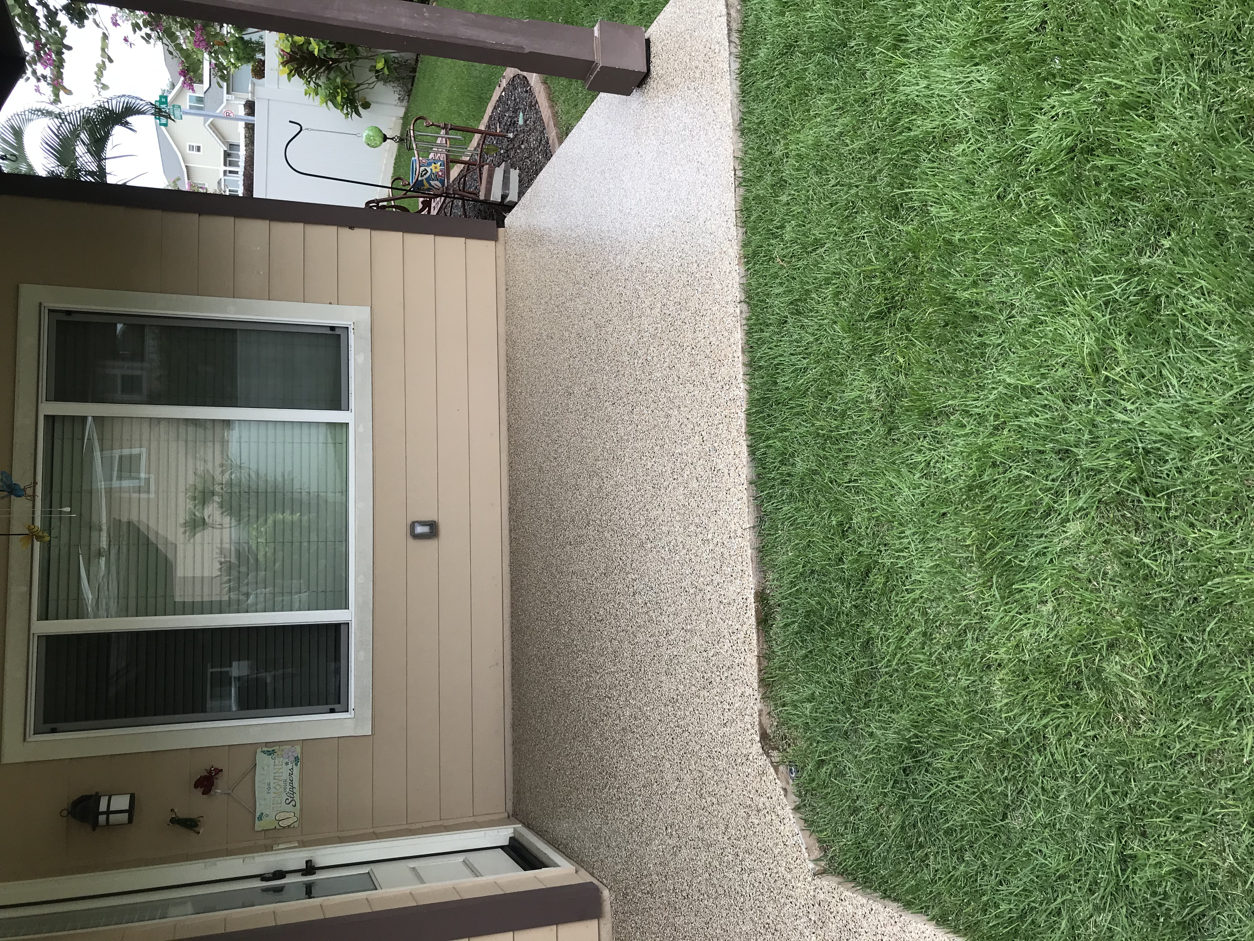 Beautifully coated concrete patio with plants and furniture.