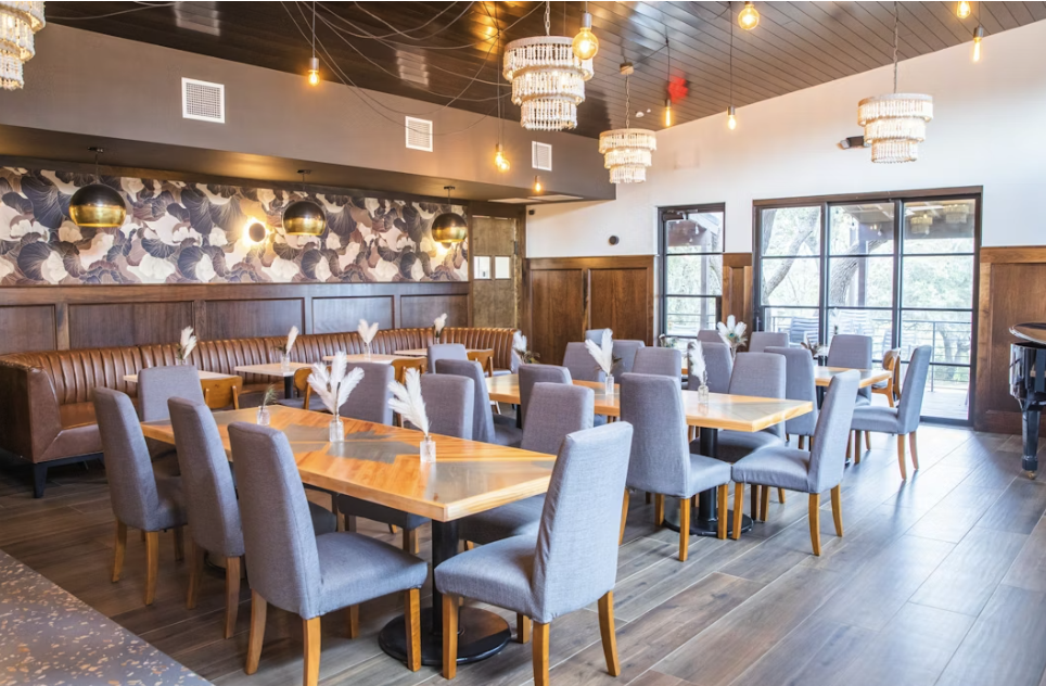 Modern restaurant dining room with booth seating and tables with chairs.