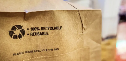 Paper bag labeled as 100% recyclable and reusable.