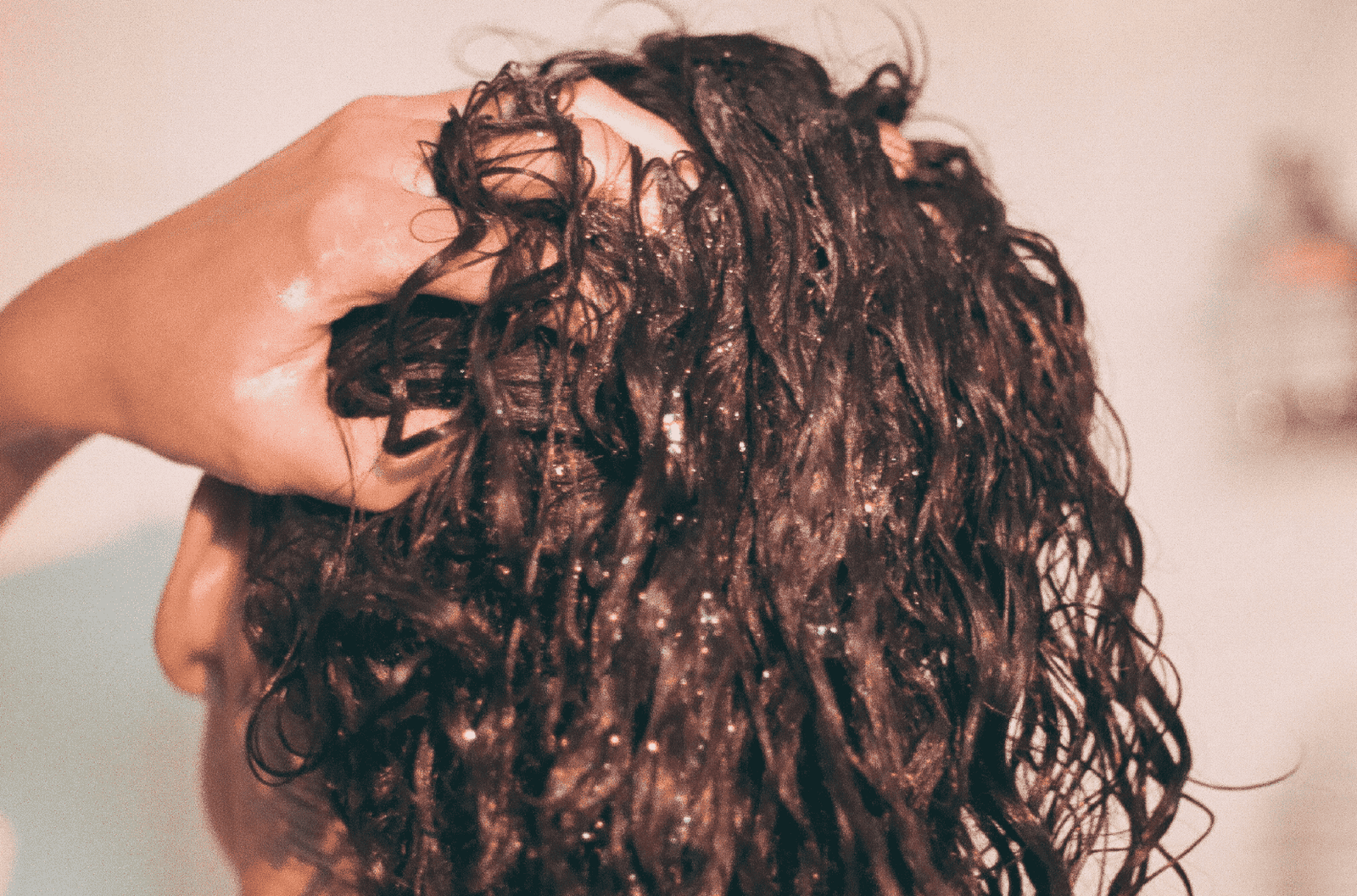 Curly hair being gently gathered by hand